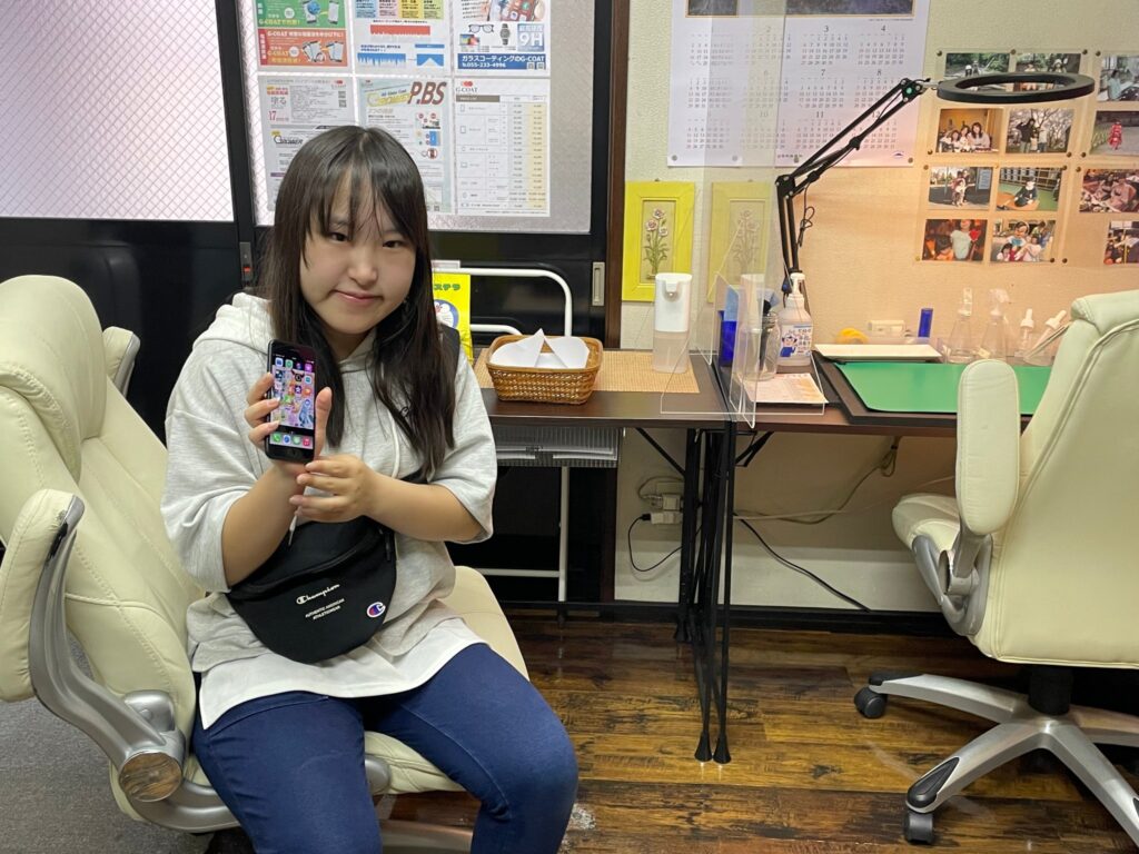 ガラスコーティング施工後のiPhone 7を持つお客様
