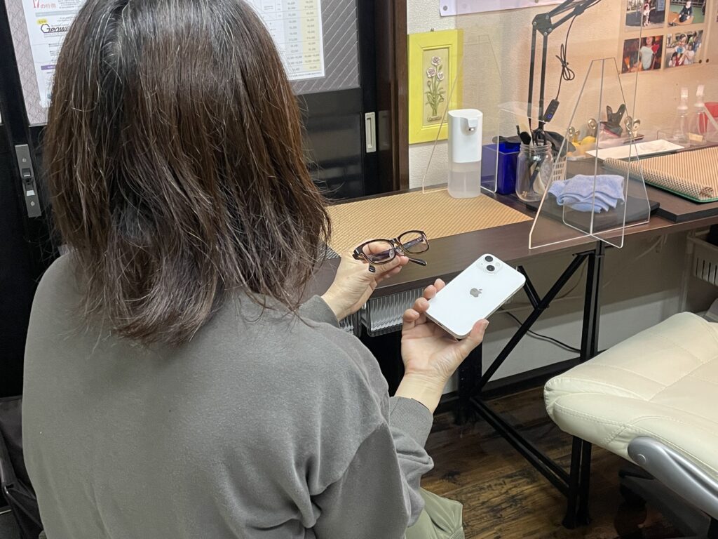 ガラスコーティング施工後のiPhone 13を確認するお客様