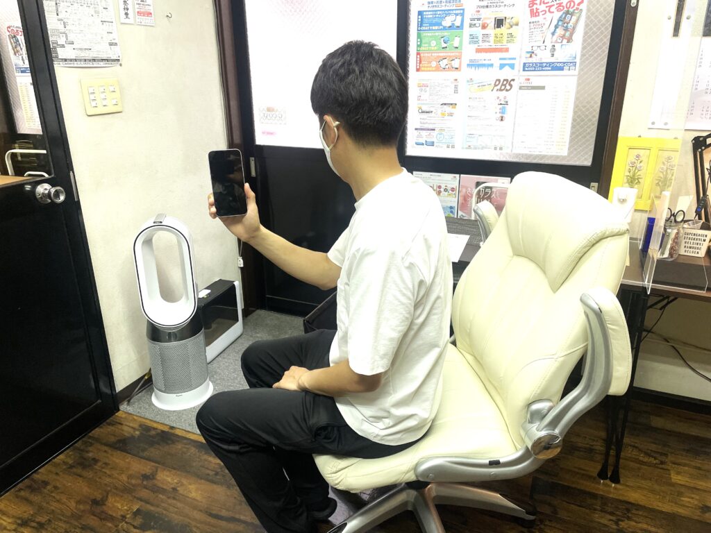 ガラスコーティング施工後のiPhone 14を持つお客様